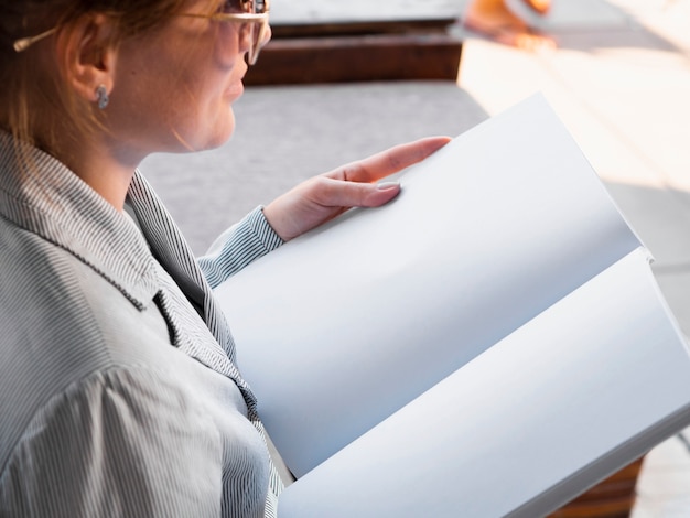 Free photo close-up woman reading a mock-up magazine