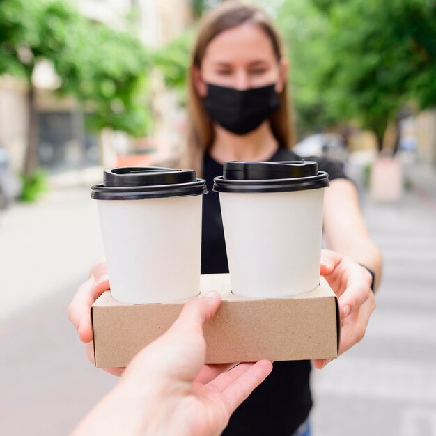 Close-up woman receiving take away coffee