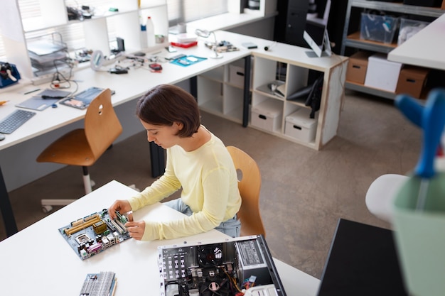 Foto gratuita primo piano sulla donna che ripara i chip del computer