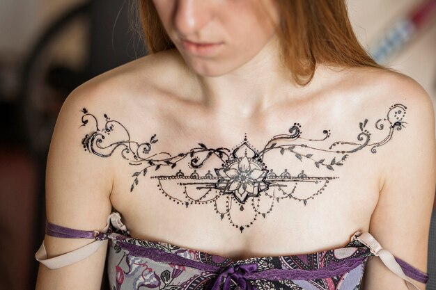 Close-up of a woman's chest with mehndi tattoo on ramadan day