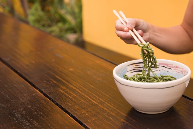 箸でゴマを食べる女性の手のクローズアップ