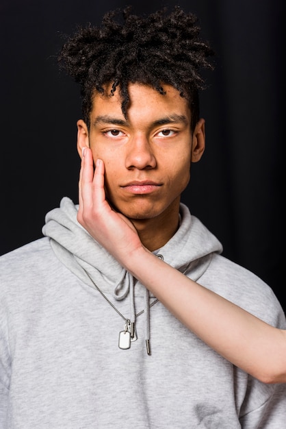 Close-up of woman's hand over her boyfriend's face against black background