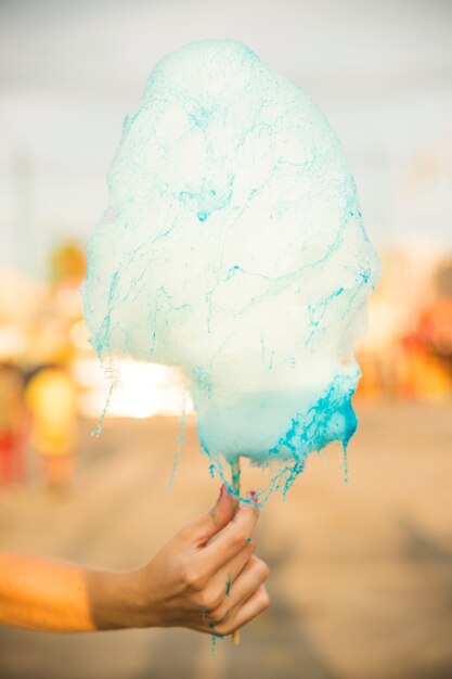 Close-up of a woman's hand holding candy floss