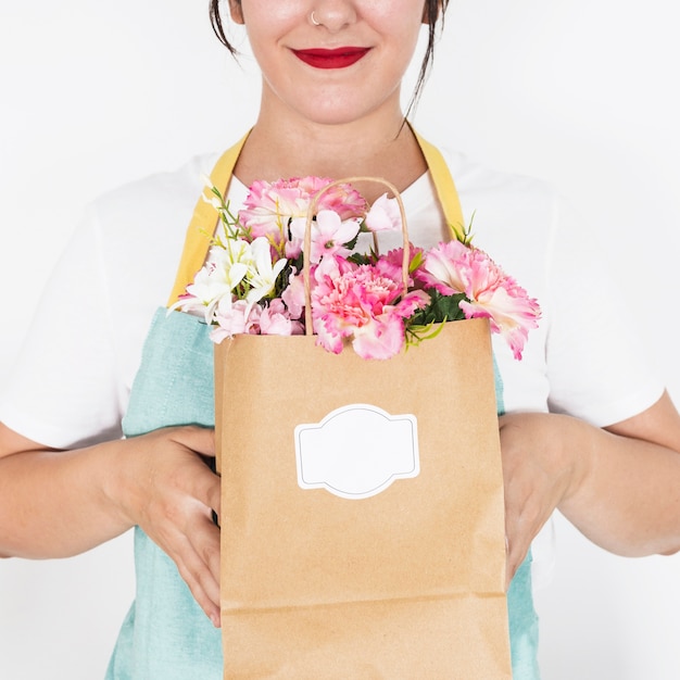 Foto gratuita primo piano della mano di una donna che tiene il sacco di carta pieno di fiori