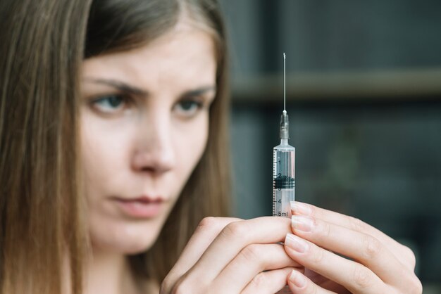 Close-up of a woman's hand holding syringe