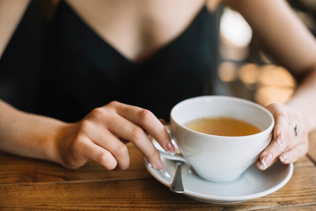 Крупным планом рука женщины, проведение чашки чая