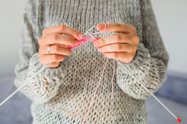 Primo piano della mano di una donna a maglia con uncinetto