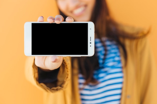 Foto gratuita primo piano della mano di una donna che mostra il telefono cellulare schermo vuoto