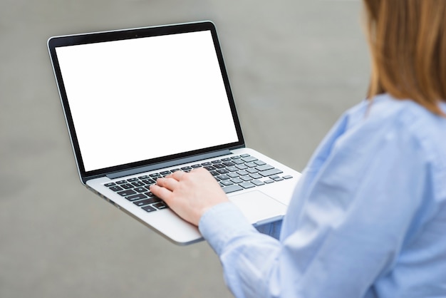 Close-up of a woman's hand typing on laptop keypad