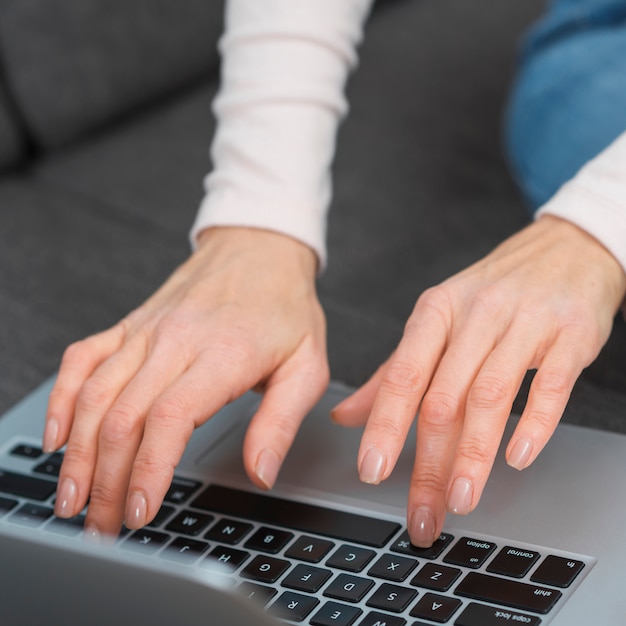 Foto gratuita primo piano della mano della donna che scrive sul computer portatile