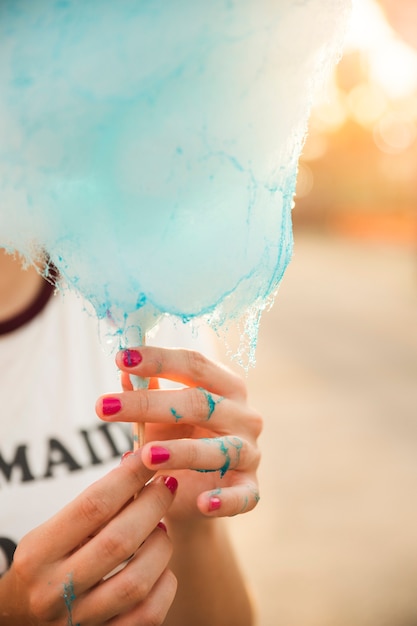 Free photo close-up of a woman's hand with blue candy floss