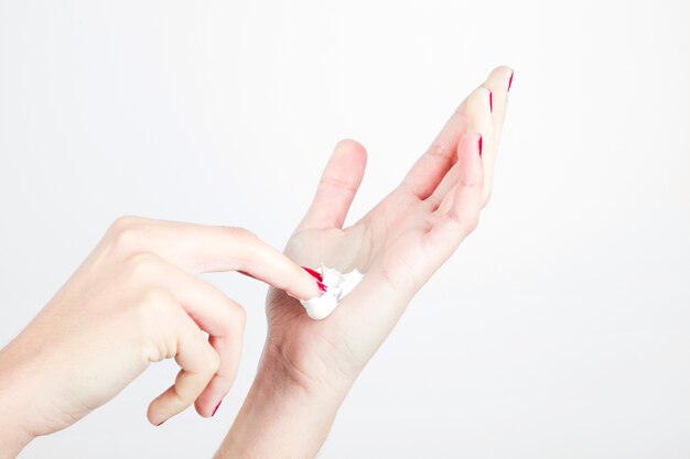 Close-up woman's hand with moisturizer isolated on white background