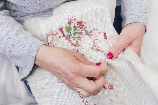 Foto gratuita primo piano della mano della donna che lavora su un pezzo di ricamo