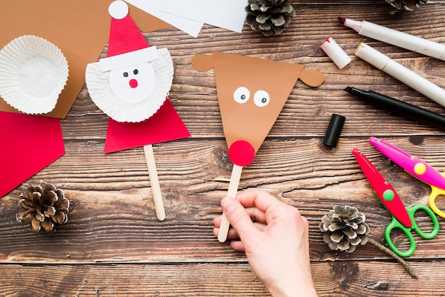 Free photo close-up of woman's handholding props made with paper on wooden desk