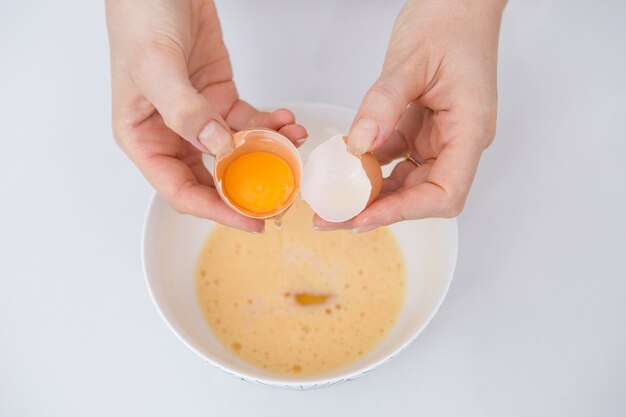 Close-up of woman separating egg at kitchen table