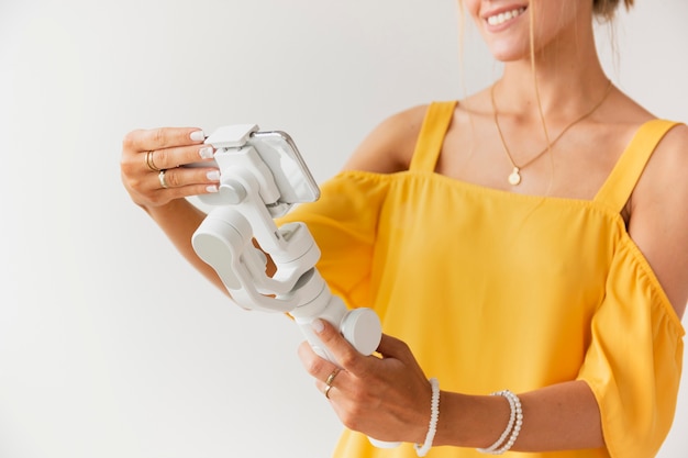 Close-up woman setting phone on filming support