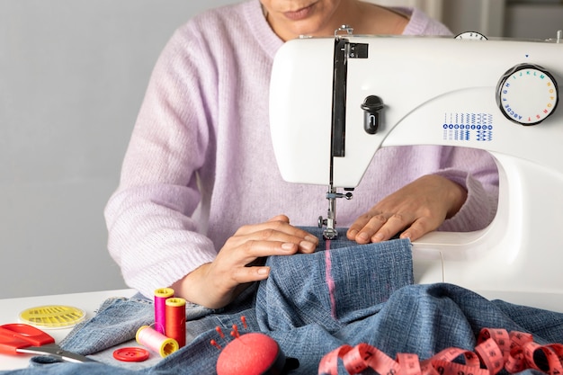 Free photo close-up woman sewing with machine