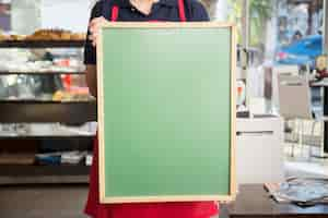 Free photo close-up of woman showing blank menu board in caf�