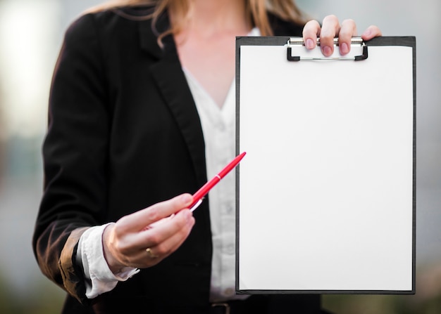 Free photo close-up woman showing clipboard mock-up