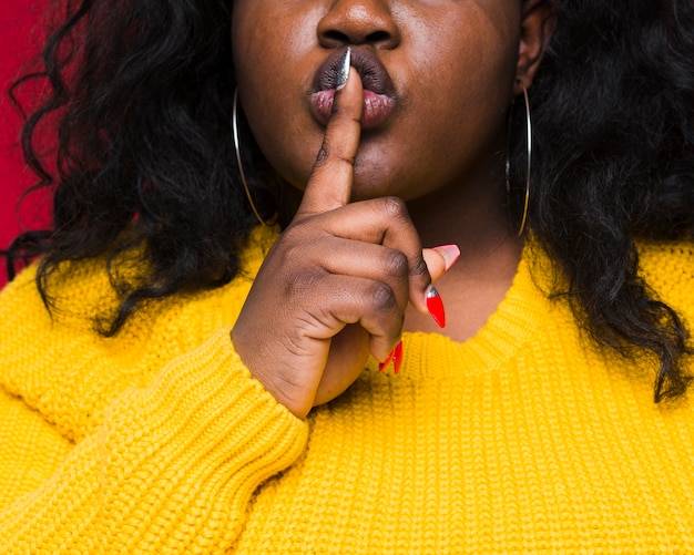 Foto gratuita donna del primo piano che mostra il segno di silenzio