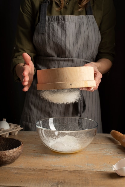 Free photo close up woman sifting flour