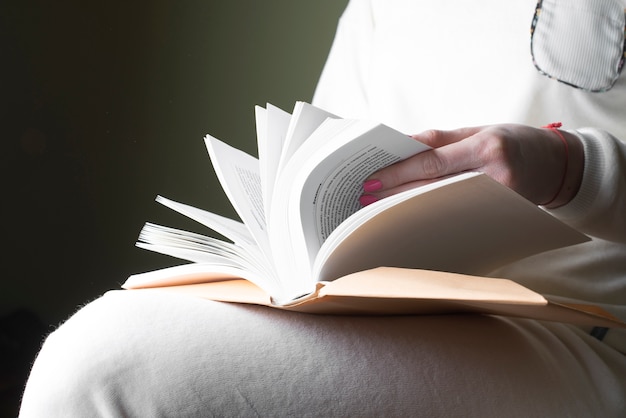 Foto gratuita primo piano della donna che si siede con un libro