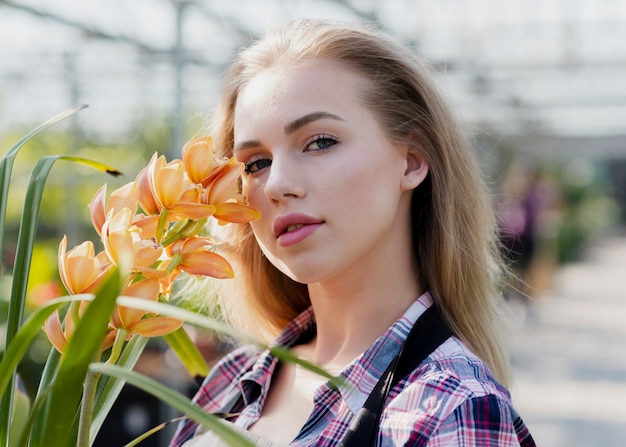 Donna del primo piano che sta accanto al fiore