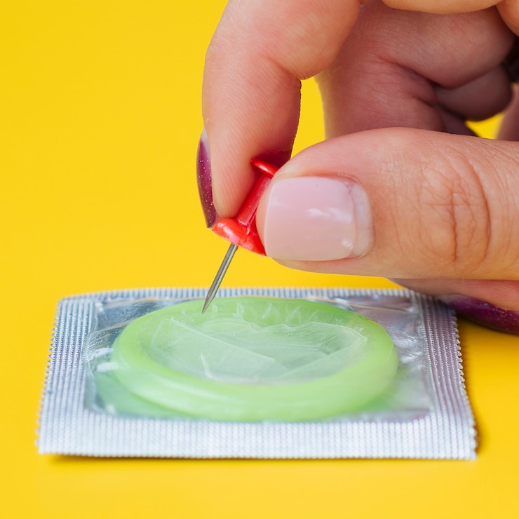 Free Photo close-up woman stinging a condom with a pin
