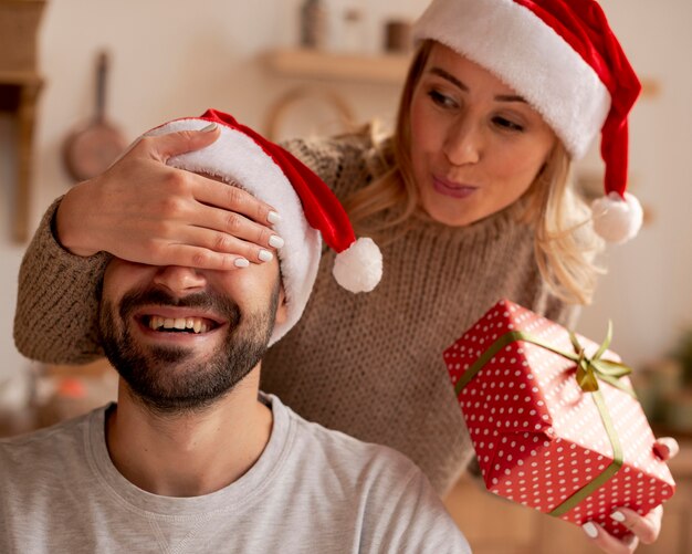 Close-up woman surprising man with gift