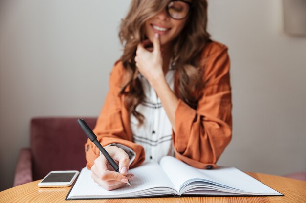 Close up of a woman taking notes in a notepad