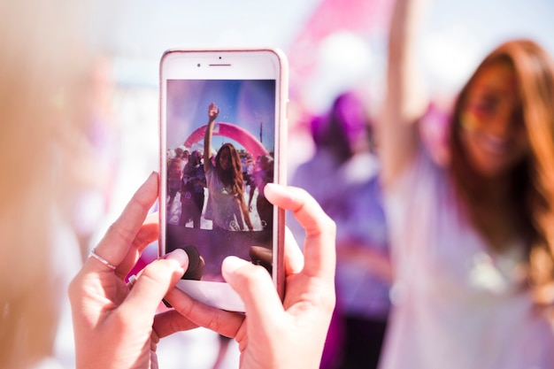 Free photo close-up woman taking photo of her friend on mobile phone