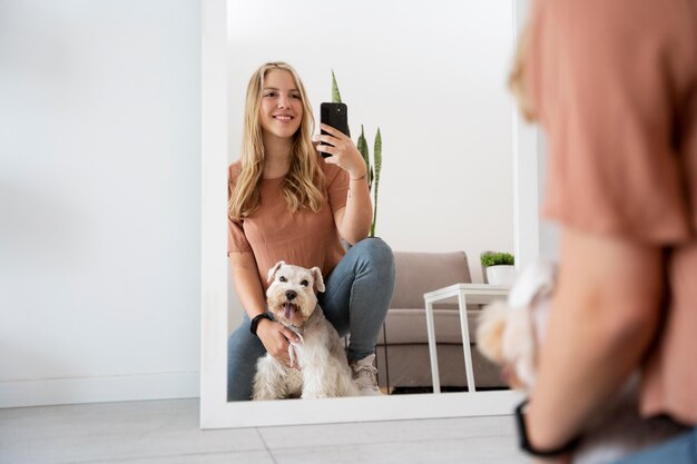 Крупным планом женщина фотографирует с собакой