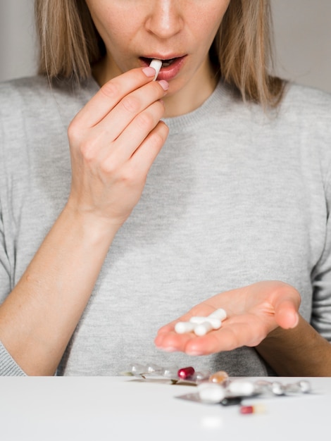 Free photo close-up woman taking pill