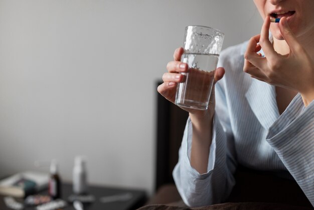 Close up woman taking pill