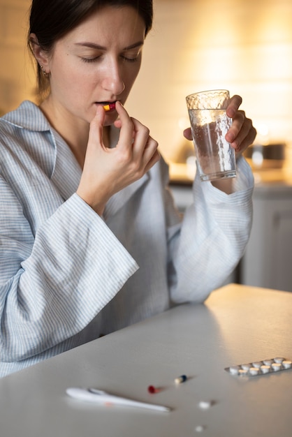 Free photo close up woman taking pills