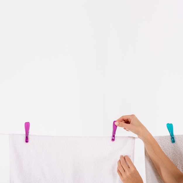 Free photo close-up woman taking towels of the clothesline