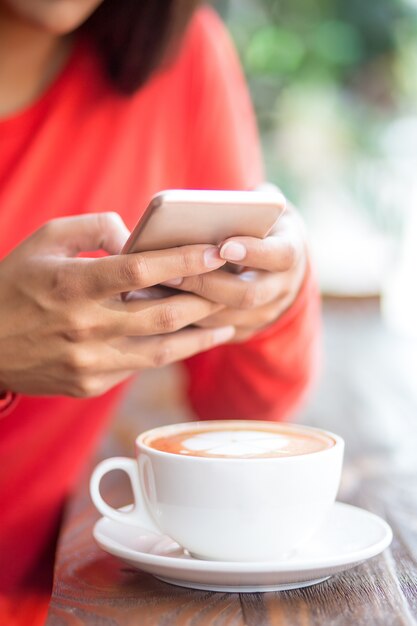 Крупный план женщина texting sms в кафе