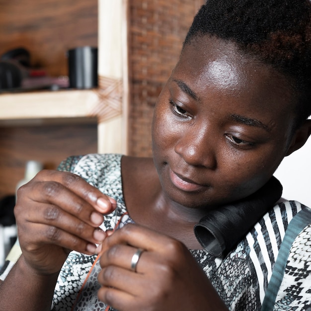 Close-up woman threading a needle