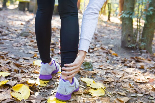 Close-up of woman touching her right ankle