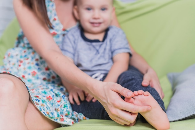 Primo piano della donna che tocca il piede del figlio