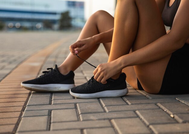 Close-up woman tying her shoelaces