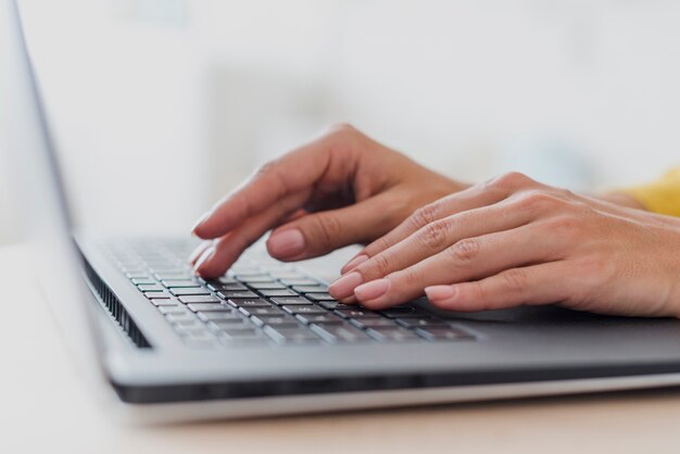 ノートパソコンのキーボードで入力するクローズアップ女性