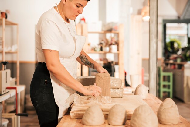 ワークショップで粘土を開梱する女性のクローズアップ