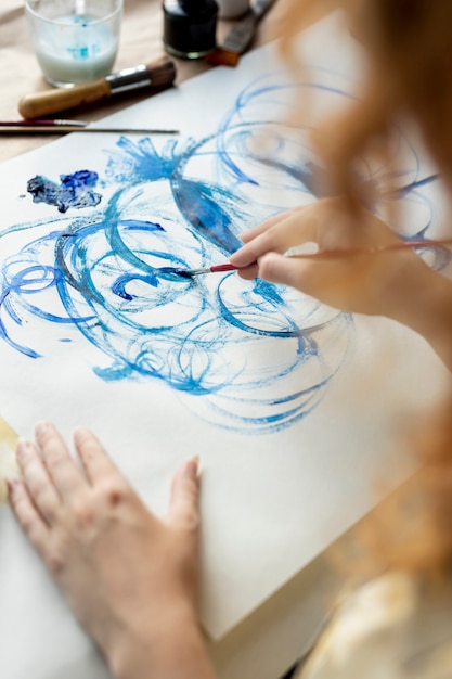 Free photo close-up woman using blue paint