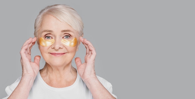 Free photo close-up woman using eye patches