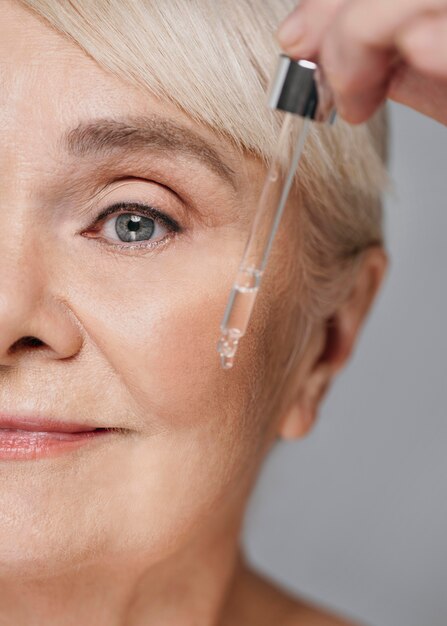 Close-up woman using face serum