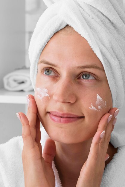 Close-up woman using facial cream