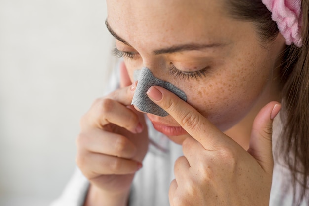 Close-up woman using nose patch