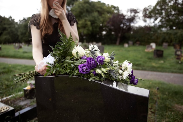 Primo piano sulla donna che visita la tomba della persona amata