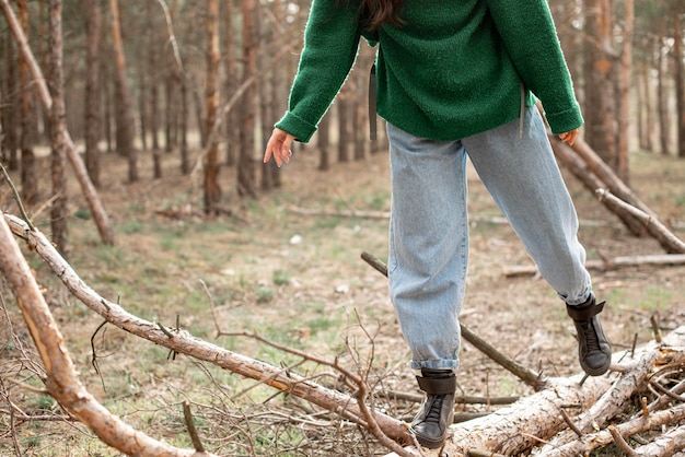 Close-up woman walking on fallen tree